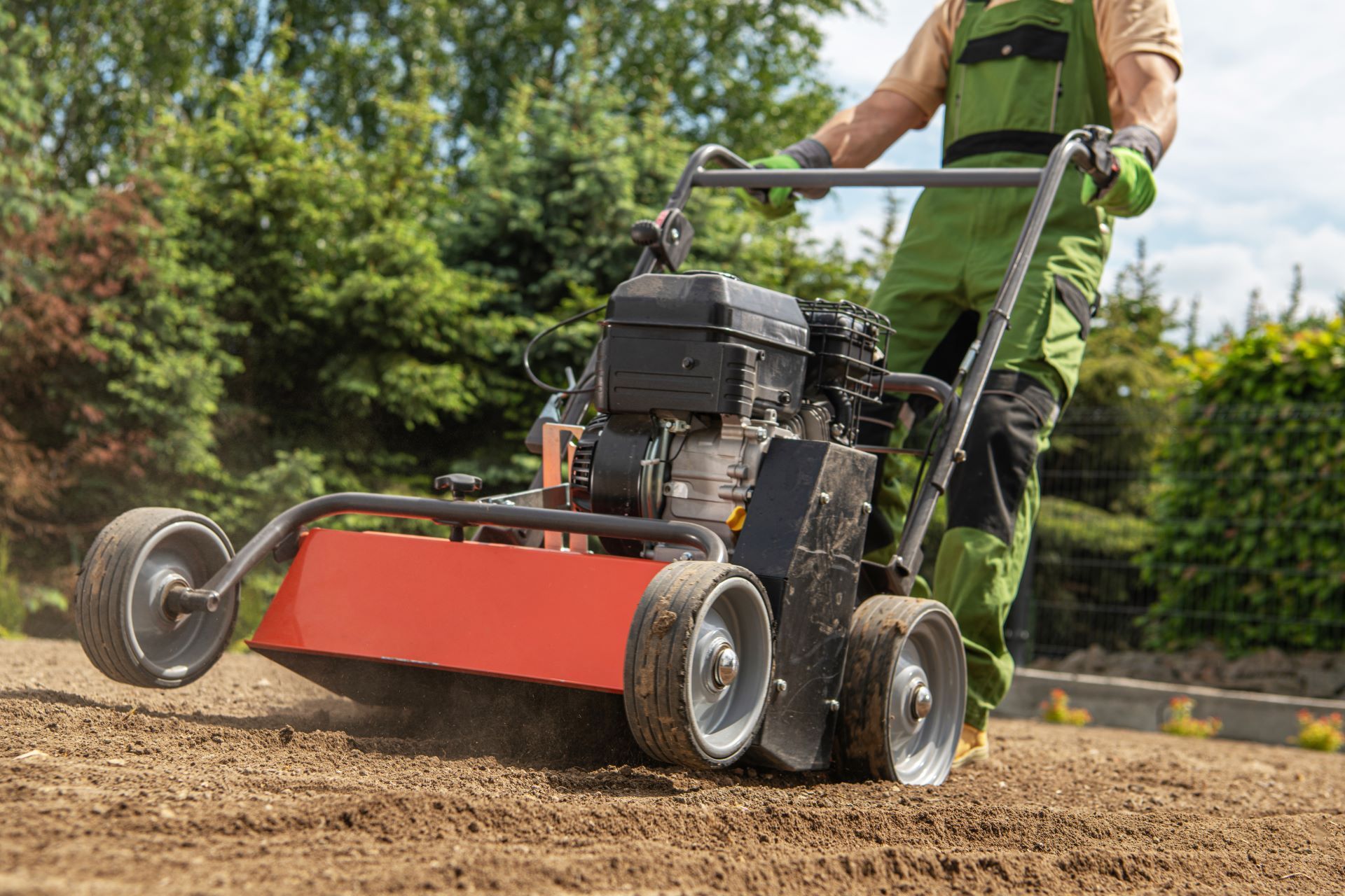 Gardener Pushing Gasoline Lawn Aerator and Preparing Soil For Nature Grass Turf Installation