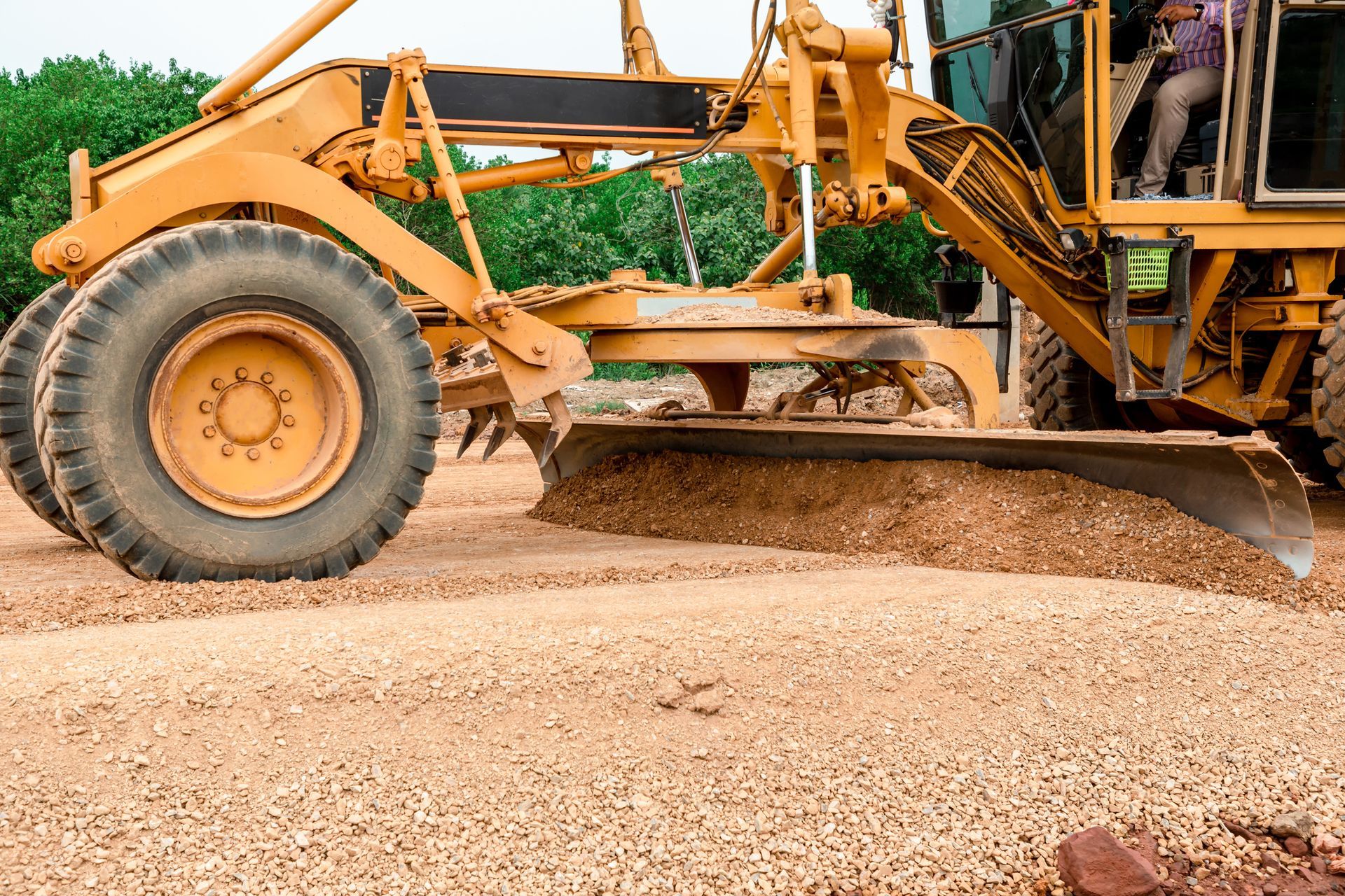 A yellow tractor is moving dirt on a construction site.