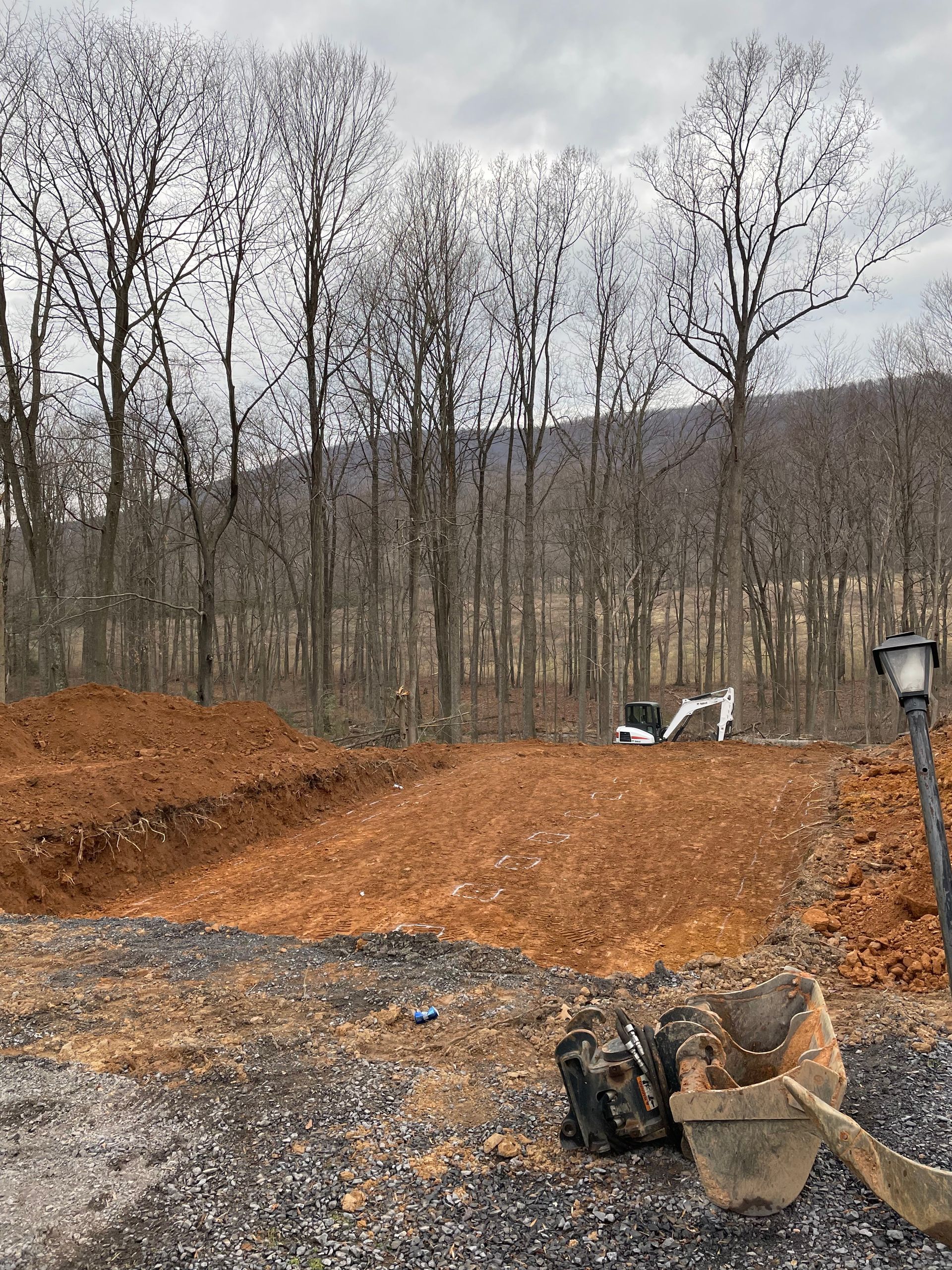 A construction site with a bulldozer in the background and a tripod in the foreground.