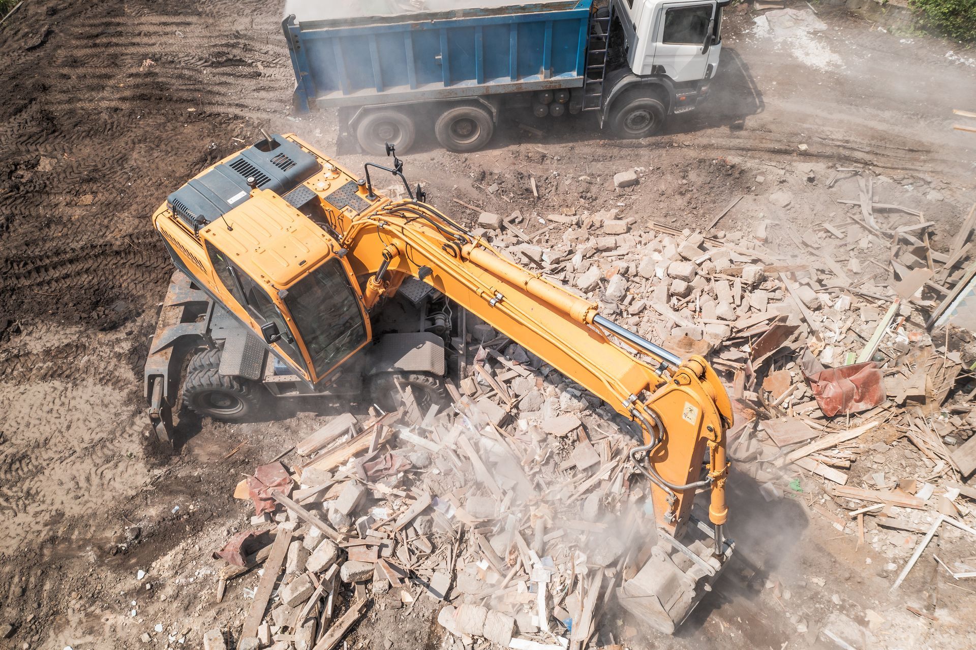 An aerial view of a construction site with a bulldozer and a dump truck.