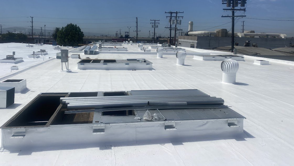 A white roof with a metal box on top of it.