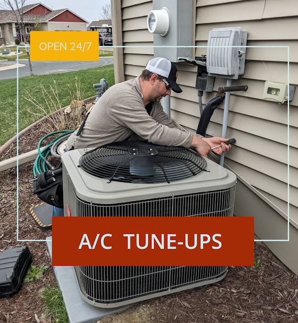 Full Time Heating & Cooling | A man is working on an air conditioner outside of a house.
