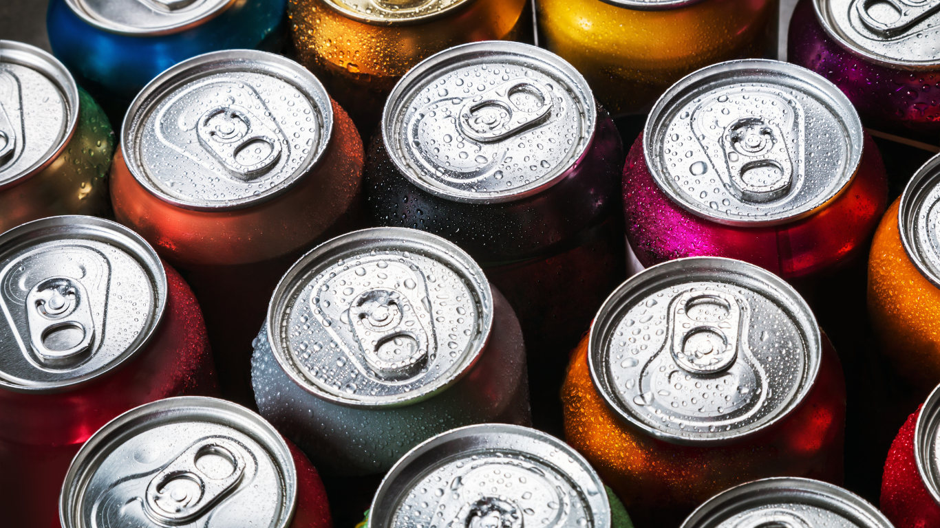A bunch of soda bottles with red caps on a red background.