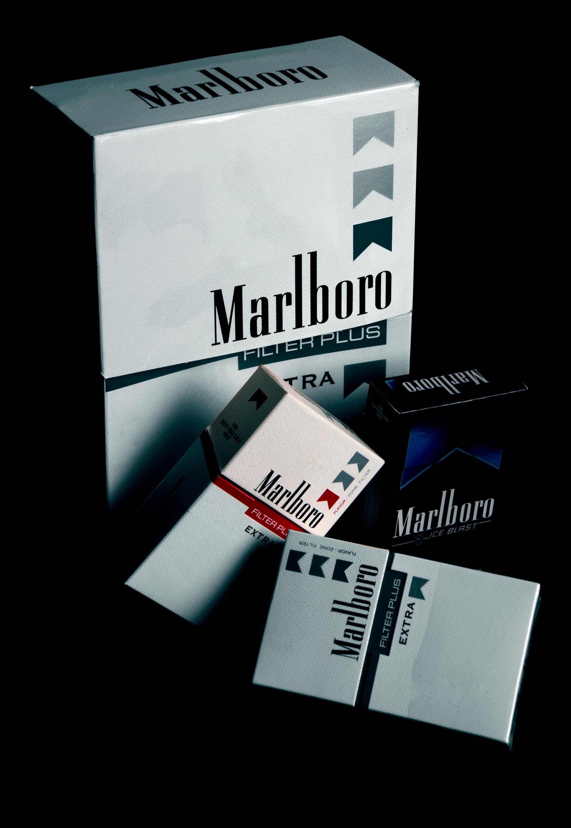 Several boxes of marlboro cigarettes are stacked on top of each other