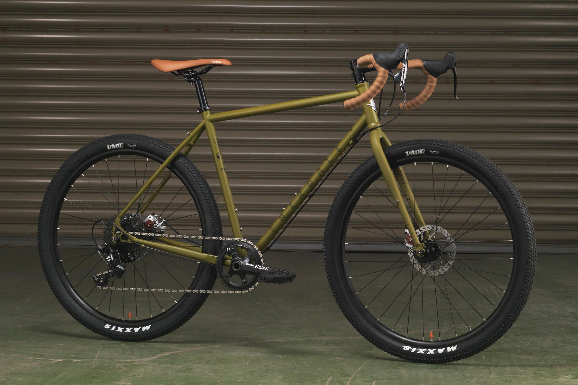 A green bicycle is parked in front of a garage door.