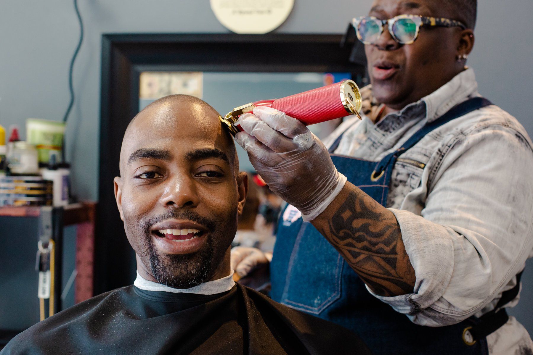 A man is getting his hair cut by a barber in a barber shop.