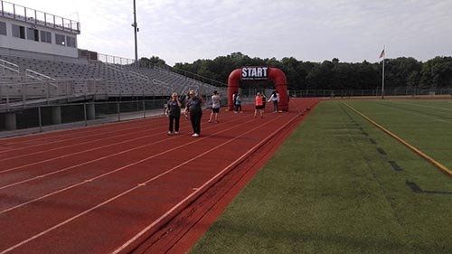 Runners at a track stadium starting line under a