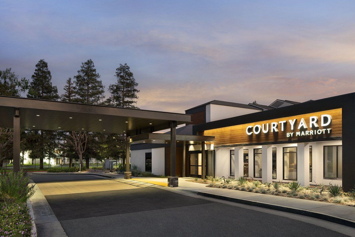 The courtyard by marriott hotel is lit up at night.