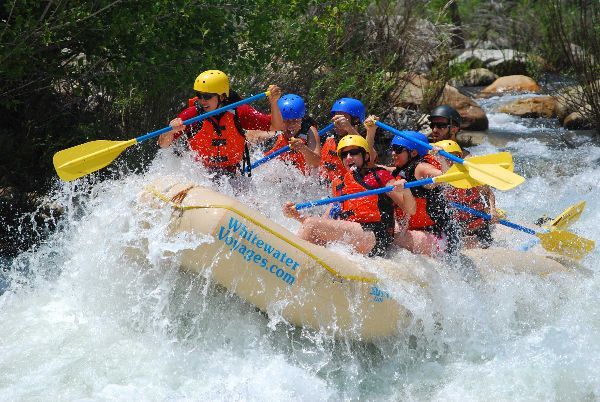 people in a yellow raft going down a rapid