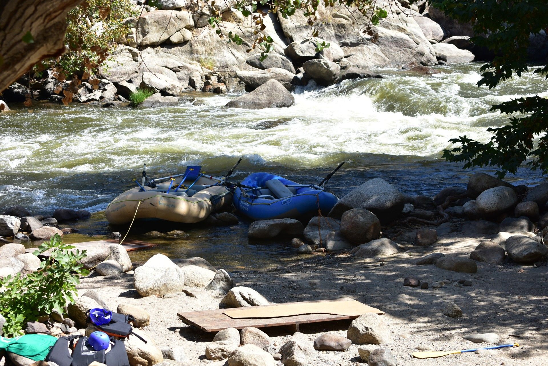 A blue raft is in the middle of a river