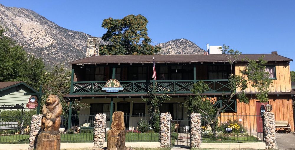 A large wooden house with a mountain in the background.