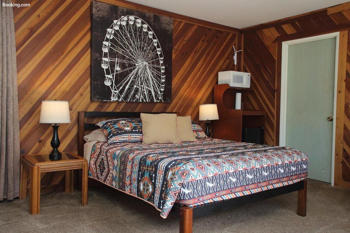 A bedroom with a ferris wheel on the wall above the bed