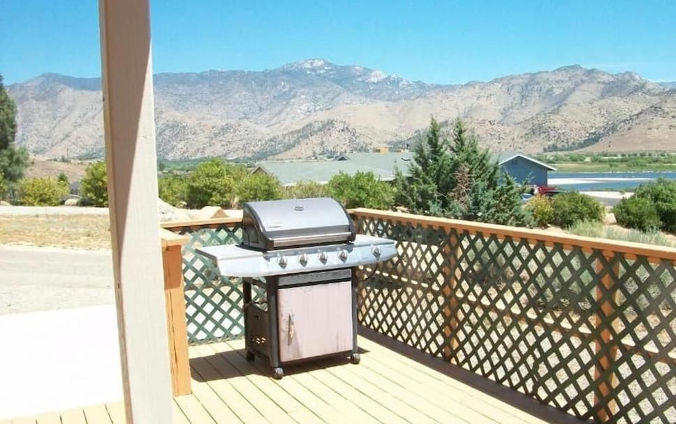A grill on a deck with mountains in the background