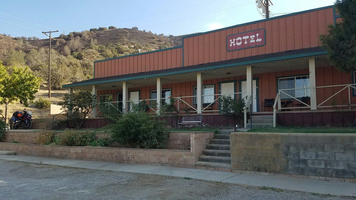A hotel with a porch and stairs in front of it.