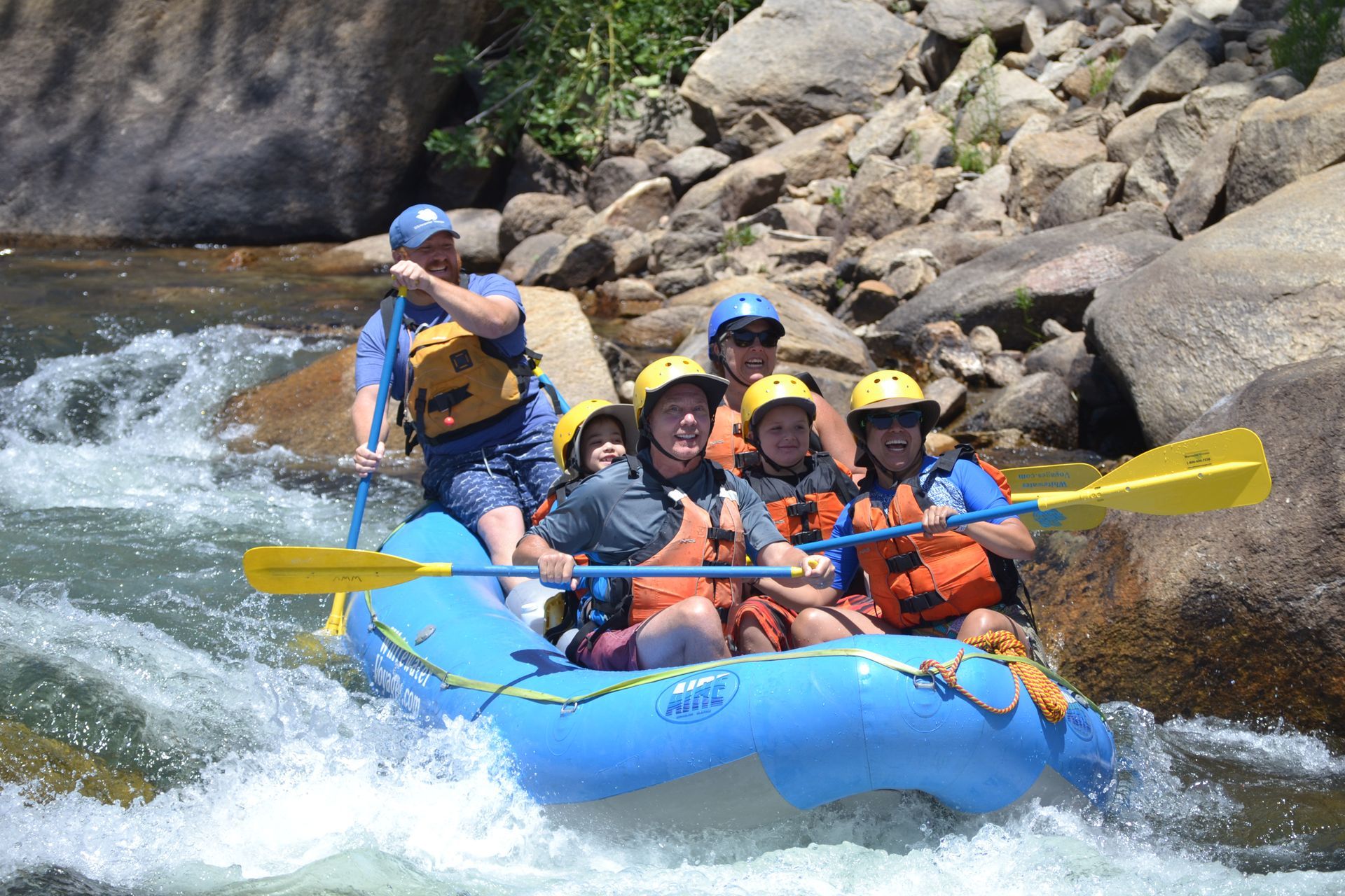Group of friends enjoying rafting down a river