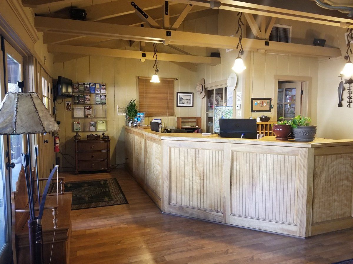 A hotel lobby with a long wooden counter and a computer on it