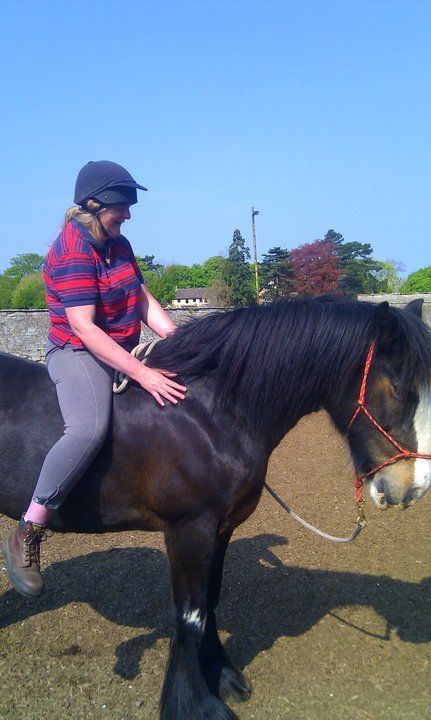 Lorraine Mitchell sitting on Dolly the horse's bare back 
