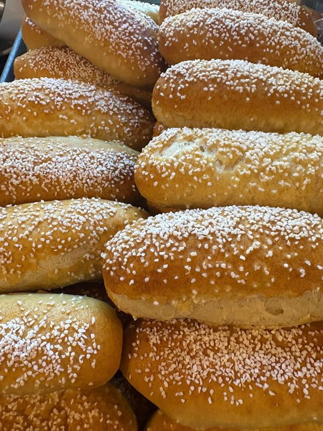 Close-up of a pile of golden-brown, oblong-shaped rolls sprinkled with white sugar crystals. Base Camp Bakery Gunnison, Colorado https://share.google/AgqUzUKNzsb0ThlP5, https://www.facebook.com/BaseCampBakery1, https://www.instagram.com/basecampbakery_81230