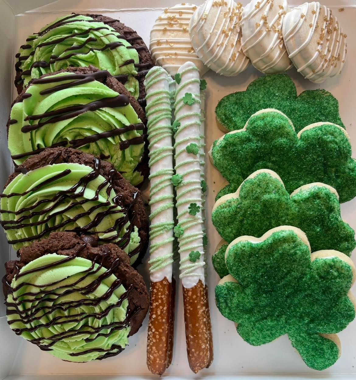 St. Patrick's Day sweets: chocolate cookies with green frosting, pretzels, shamrock cookies, and cake pops. Base Camp Bakery Gunnison, Colorado https://share.google/AgqUzUKNzsb0ThlP5, https://www.facebook.com/BaseCampBakery1, https://www.instagram.com/basecampbakery_81230