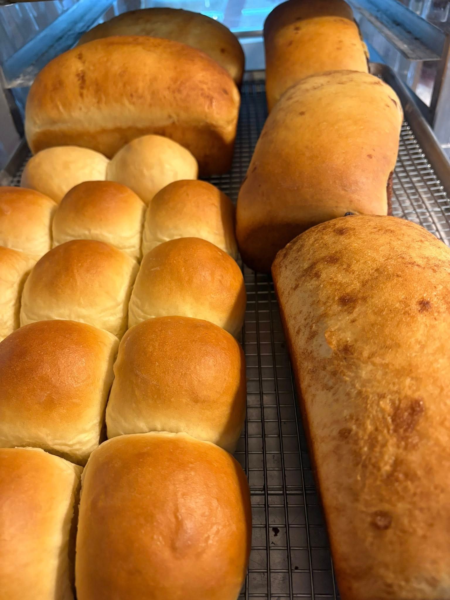 Freshly baked bread and rolls on a cooling rack. Base Camp Bakery Gunnison, Colorado https://share.google/AgqUzUKNzsb0ThlP5, https://www.facebook.com/BaseCampBakery1, https://www.instagram.com/basecampbakery_81230