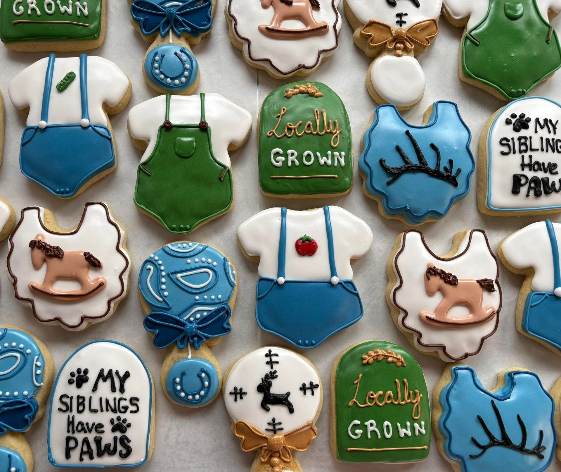 Decorated sugar cookies with farm animal and baby clothes designs in various colors. Base Camp Bakery Gunnison, Colorado https://share.google/AgqUzUKNzsb0ThlP5, https://www.facebook.com/BaseCampBakery1, https://www.instagram.com/basecampbakery_81230