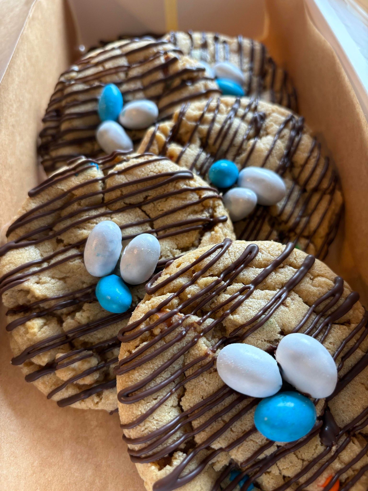 Cookies drizzled with chocolate and decorated with blue and white candy. Base Camp Bakery Gunnison, Colorado https://share.google/AgqUzUKNzsb0ThlP5, https://www.facebook.com/BaseCampBakery1, https://www.instagram.com/basecampbakery_81230