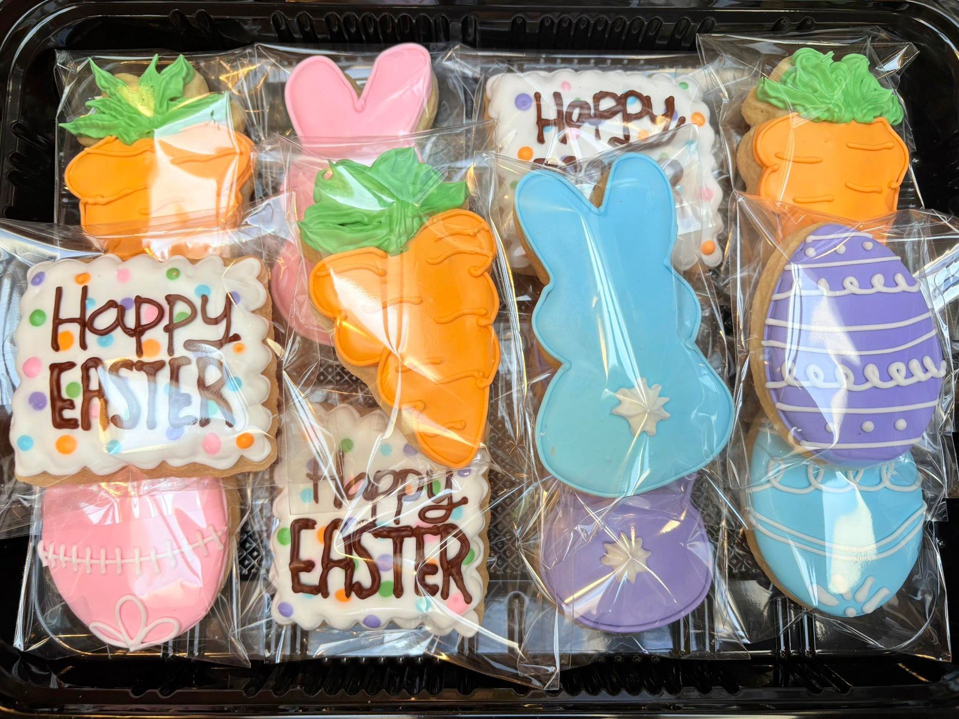 Easter cookies in a tray, decorated with carrots, bunnies, eggs. Base Camp Bakery Gunnison, Colorado https://share.google/AgqUzUKNzsb0ThlP5, https://www.facebook.com/BaseCampBakery1, https://www.instagram.com/basecampbakery_81230