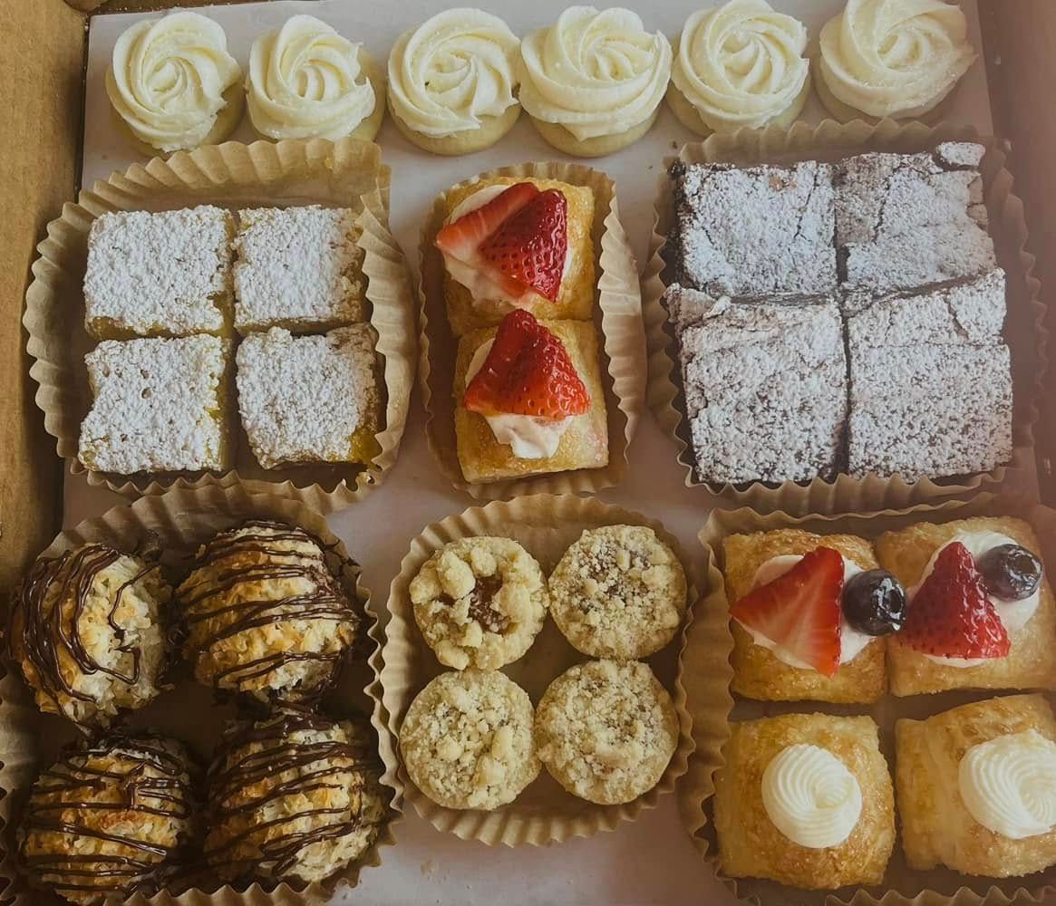 Box of assorted pastries: shortbread, brownies, tarts, cookies with powdered sugar and icing. Base Camp Bakery Gunnison, Colorado https://share.google/AgqUzUKNzsb0ThlP5, https://www.facebook.com/BaseCampBakery1, https://www.instagram.com/basecampbakery_81230