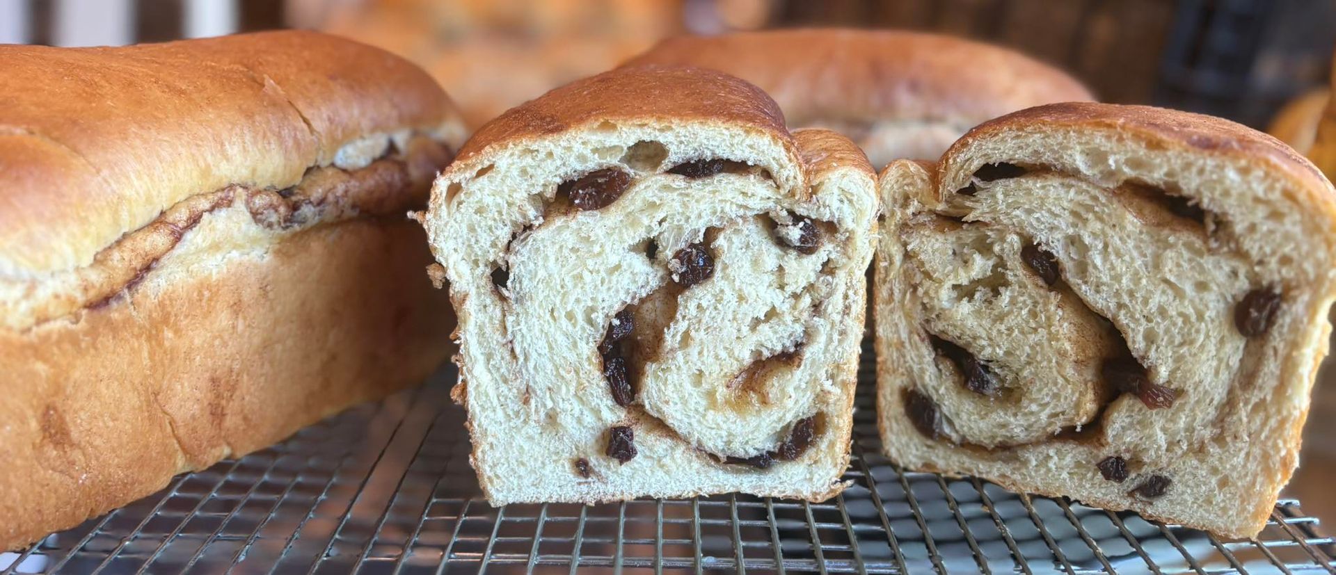 Sliced raisin bread loaf on a cooling rack. Base Camp Bakery Gunnison, Colorado https://share.google/AgqUzUKNzsb0ThlP5, https://www.facebook.com/BaseCampBakery1, https://www.instagram.com/basecampbakery_81230