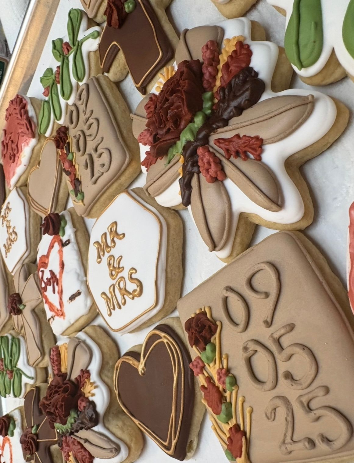 Decorated sugar cookies with wedding theme: dates, florals. Base Camp Bakery Gunnison, Colorado https://share.google/AgqUzUKNzsb0ThlP5, https://www.facebook.com/BaseCampBakery1, https://www.instagram.com/basecampbakery_81230