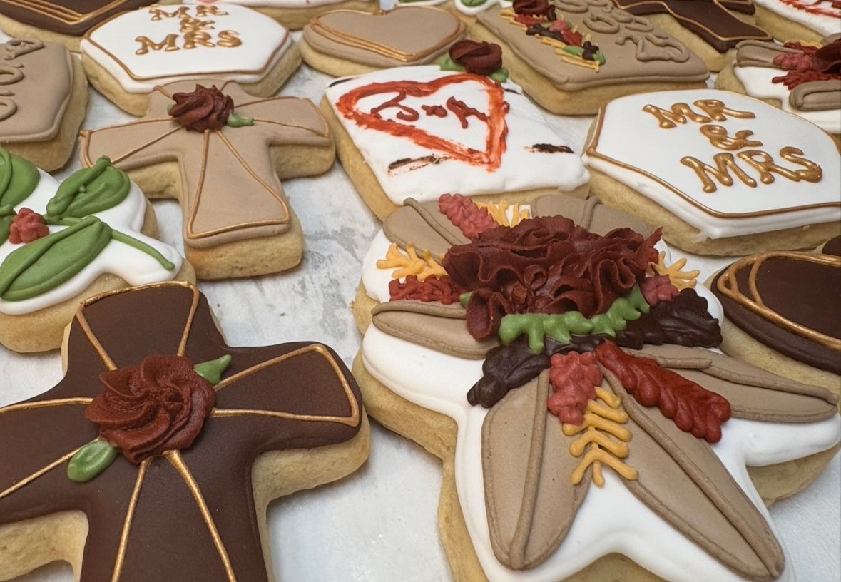Decorated sugar cookies with wedding-themed frosting. Cross, heart, and square shapes, with fall colors. Base Camp Bakery Gunnison, Colorado https://share.google/AgqUzUKNzsb0ThlP5, https://www.facebook.com/BaseCampBakery1, https://www.instagram.com/basecampbakery_81230