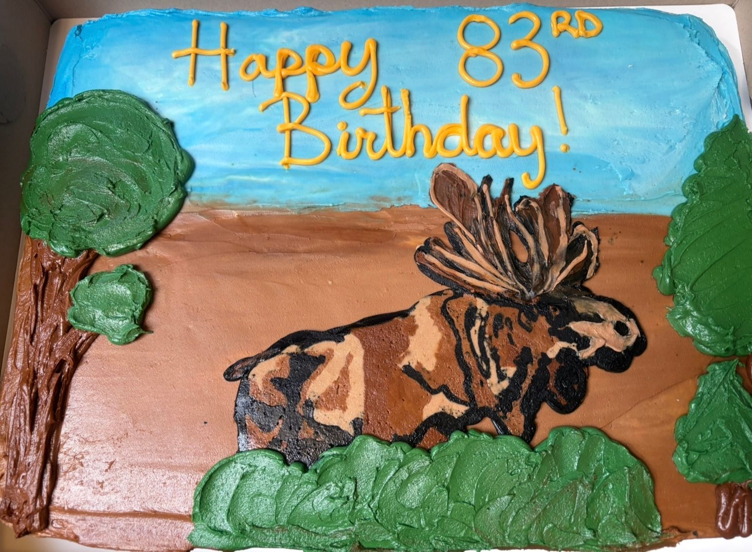 Cake decorated with a moose, trees. Base Camp Bakery Gunnison, Colorado https://share.google/AgqUzUKNzsb0ThlP5, https://www.facebook.com/BaseCampBakery1, https://www.instagram.com/basecampbakery_81230
