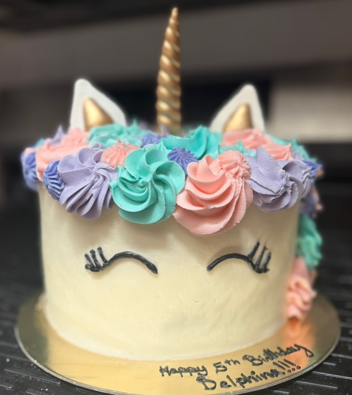 Unicorn cake with frosting mane of pink, teal, and purple rosettes. Gold horn and ears. Base Camp Bakery Gunnison, Colorado https://share.google/AgqUzUKNzsb0ThlP5, https://www.facebook.com/BaseCampBakery1, https://www.instagram.com/basecampbakery_81230