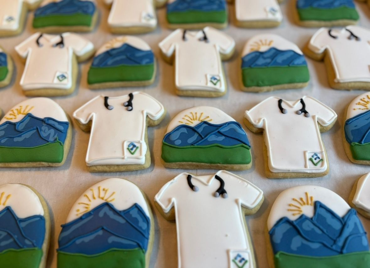 Cookies decorated as mountains and scrub tops. White icing, blue, green, and gold details. Base Camp Bakery Gunnison, Colorado https://share.google/AgqUzUKNzsb0ThlP5, https://www.facebook.com/BaseCampBakery1, https://www.instagram.com/basecampbakery_81230