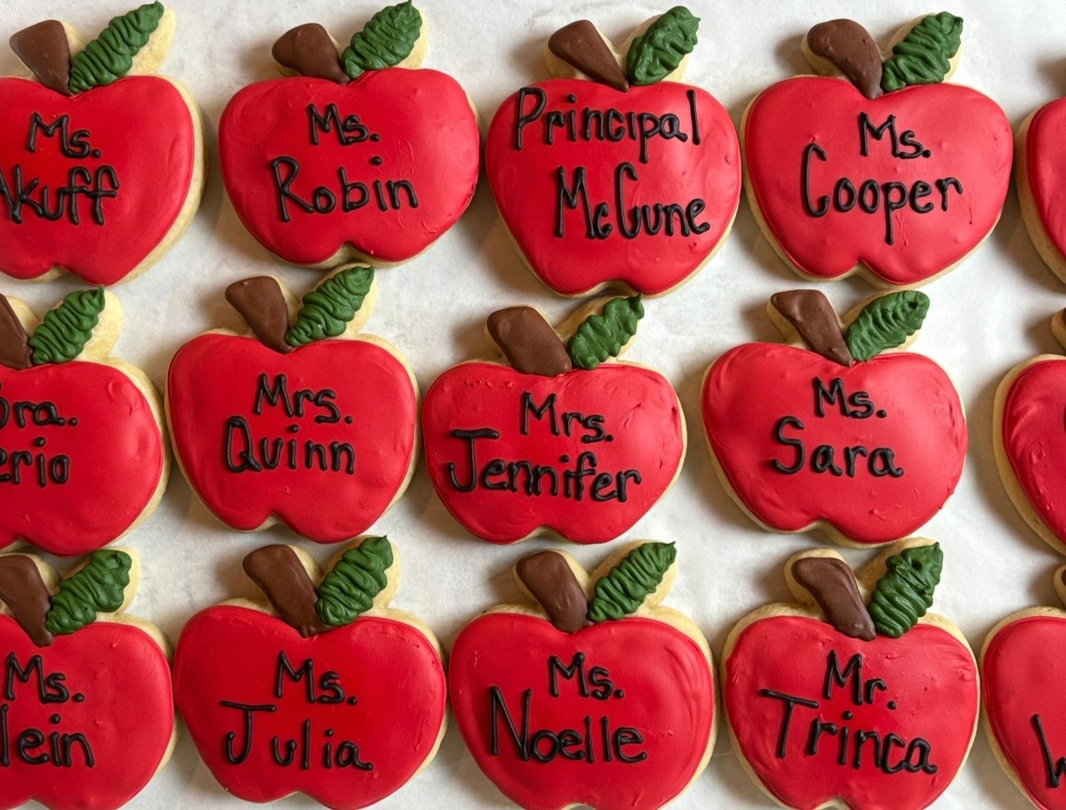 Red apple cookies iced with teachers' names. Base Camp Bakery Gunnison, Colorado https://share.google/AgqUzUKNzsb0ThlP5, https://www.facebook.com/BaseCampBakery1, https://www.instagram.com/basecampbakery_81230