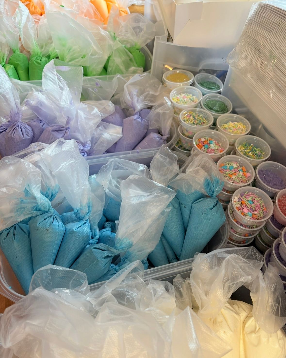Rows of colorful icing bags and sprinkle containers, likely for decorating baked goods. Base Camp Bakery Gunnison, Colorado https://share.google/AgqUzUKNzsb0ThlP5, https://www.facebook.com/BaseCampBakery1, https://www.instagram.com/basecampbakery_81230