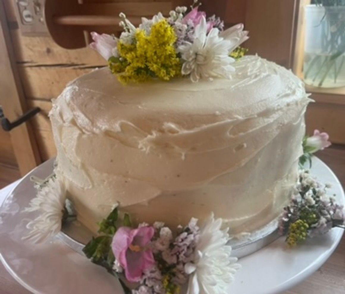 Cake with white frosting and floral decorations. Base Camp Bakery Gunnison, Colorado https://share.google/AgqUzUKNzsb0ThlP5, https://www.facebook.com/BaseCampBakery1, https://www.instagram.com/basecampbakery_81230