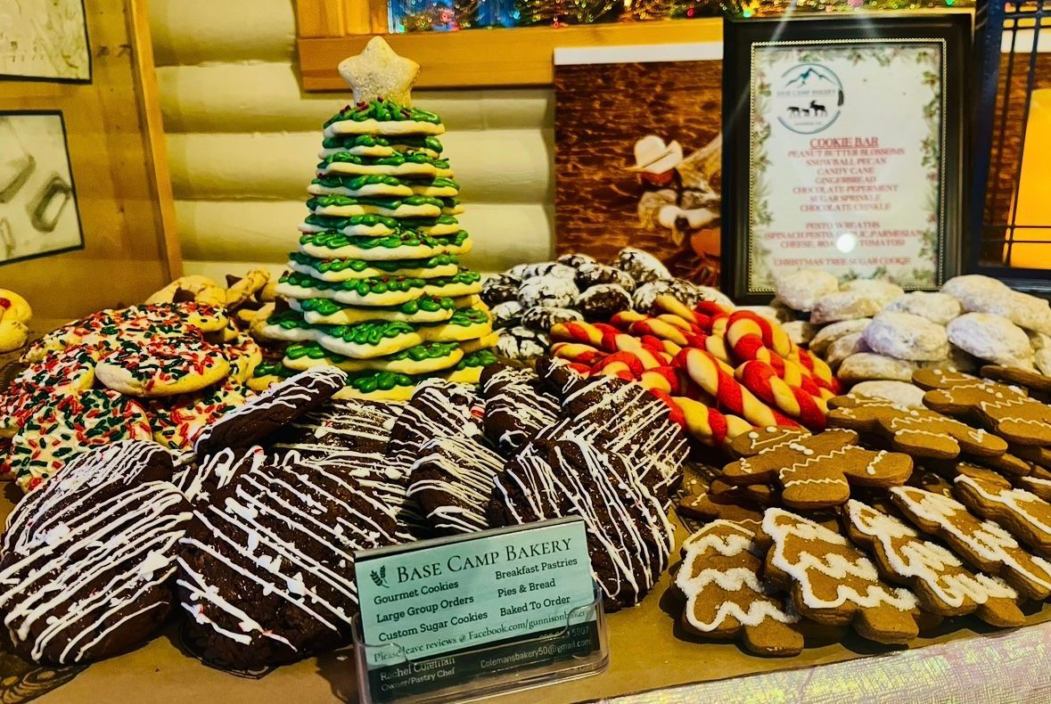 Display of Christmas cookies, including decorated sugar cookies, gingerbread men, and a tree-shaped cake. Base Camp Bakery Gunnison, Colorado https://share.google/AgqUzUKNzsb0ThlP5, https://www.facebook.com/BaseCampBakery1, https://www.instagram.com/basecampbakery_81230