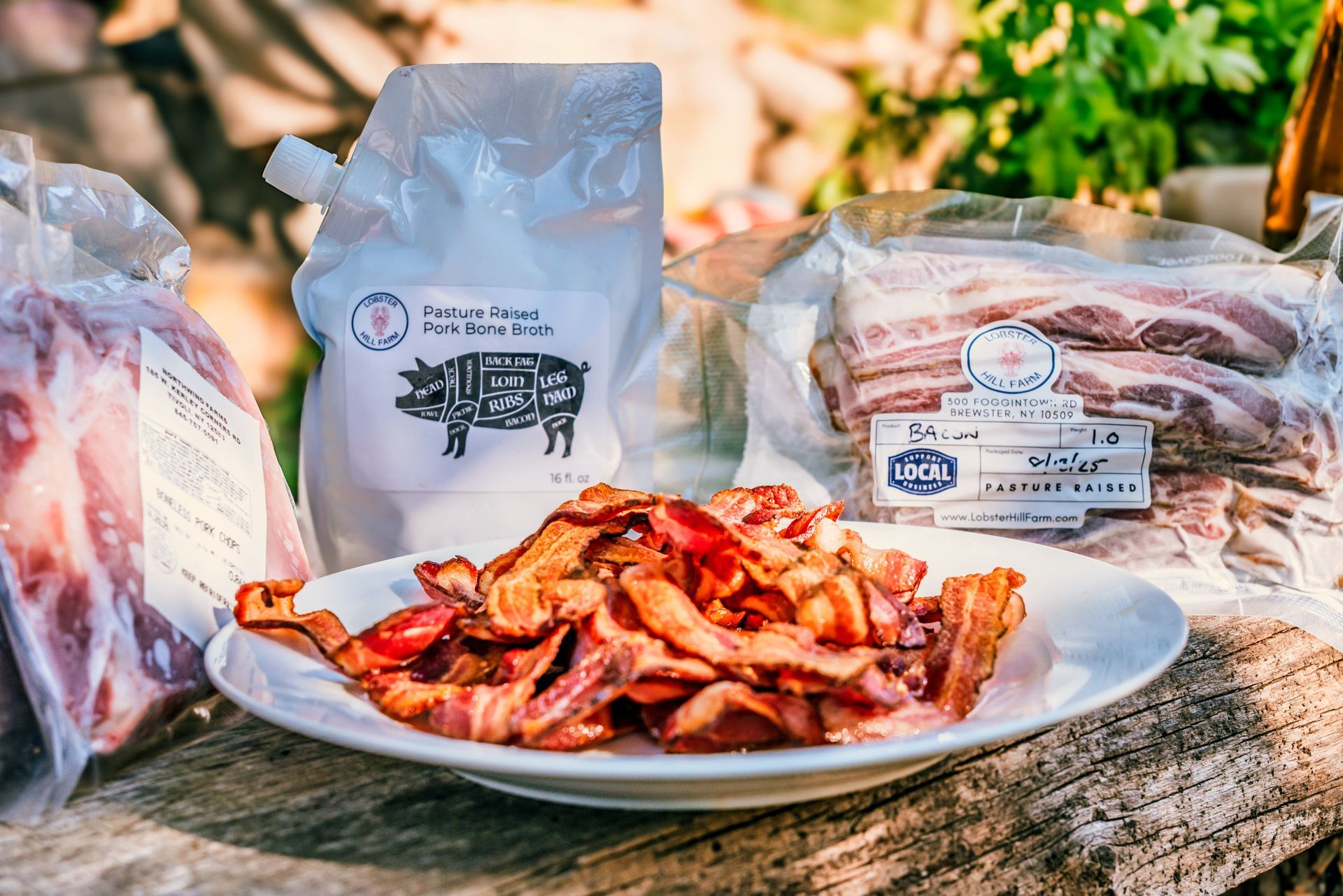 Plate of cooked bacon with packaged raw bacon and pork products.