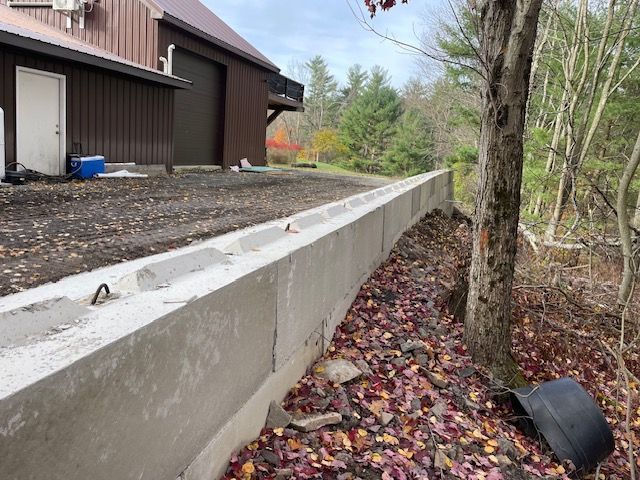 A Concrete Wall is Being Built in Front of a Barn