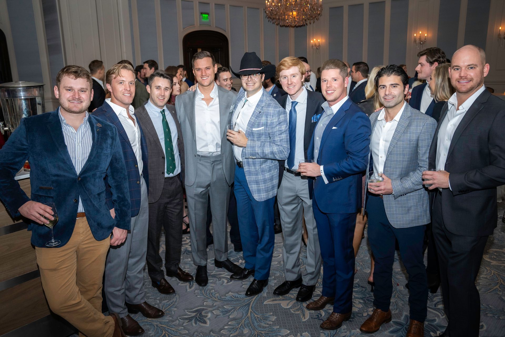 A group of men in suits are posing for a picture at a party.