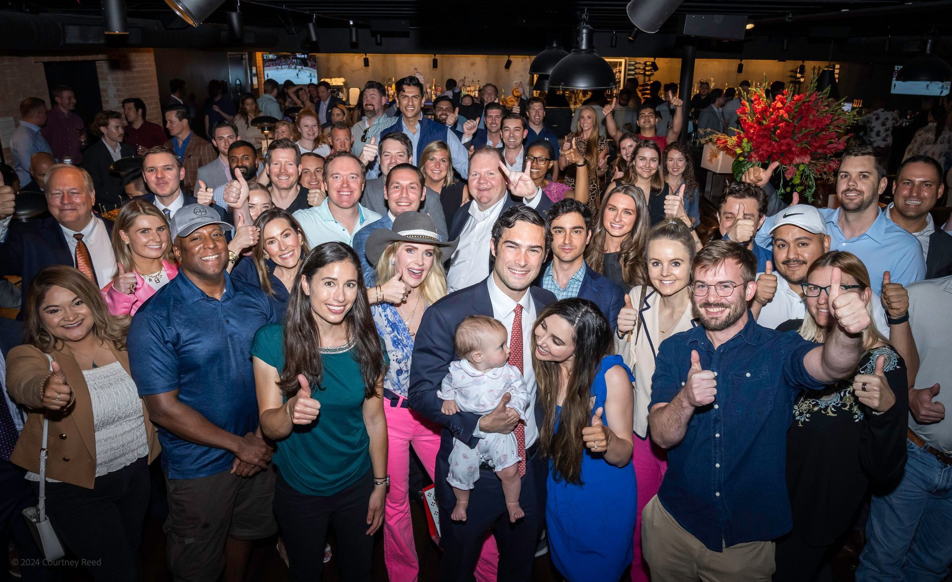A large group of people are posing for a picture at a party.