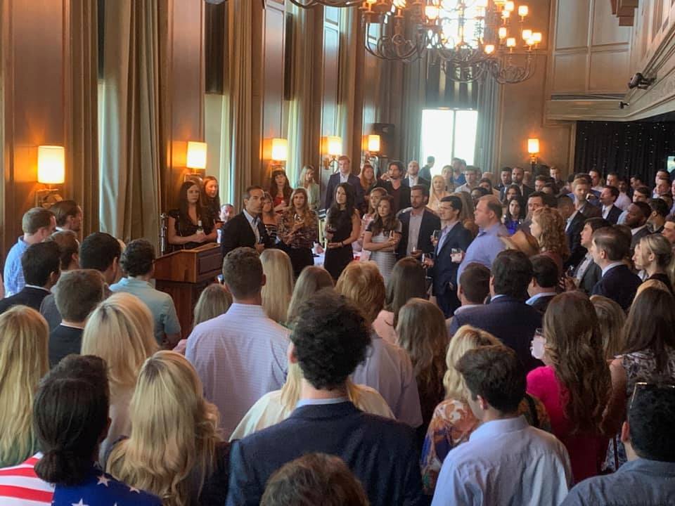 A large group of people are standing in a room.