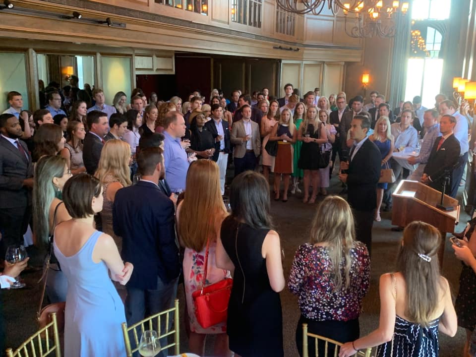 A large group of people are standing in a room.