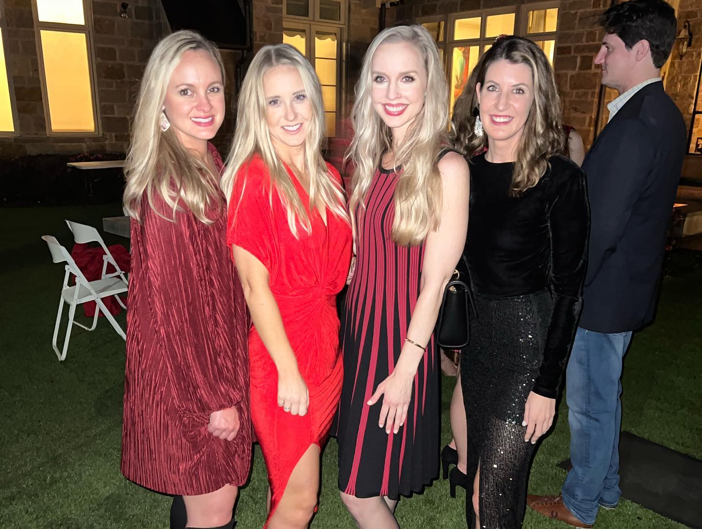 A group of women are posing for a picture in front of a building.