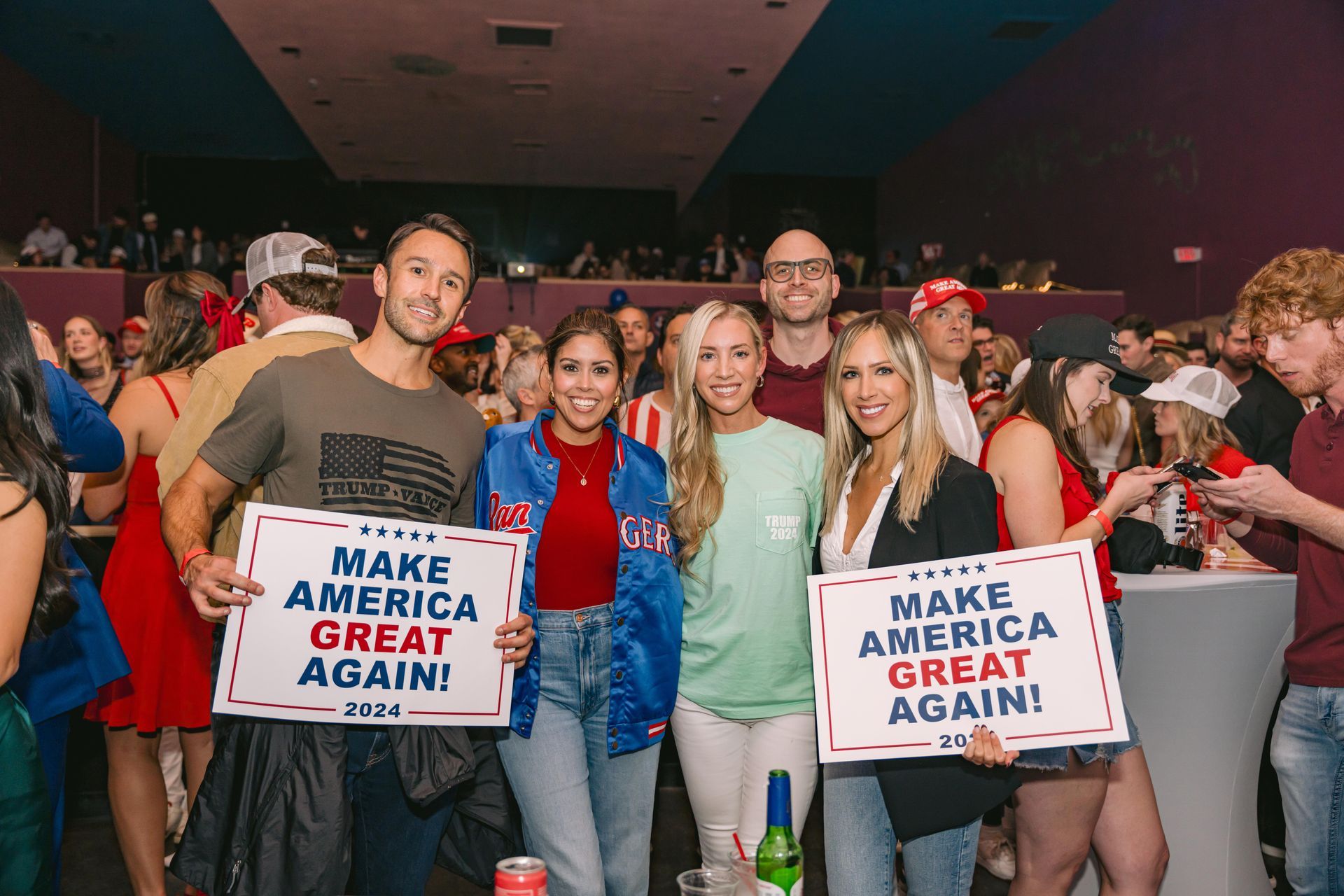 A group of people are holding signs that say `` make america great again ''.