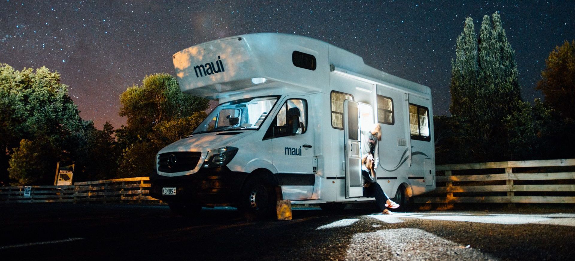 Un camper bianco è parcheggiato sul ciglio della strada di notte.
