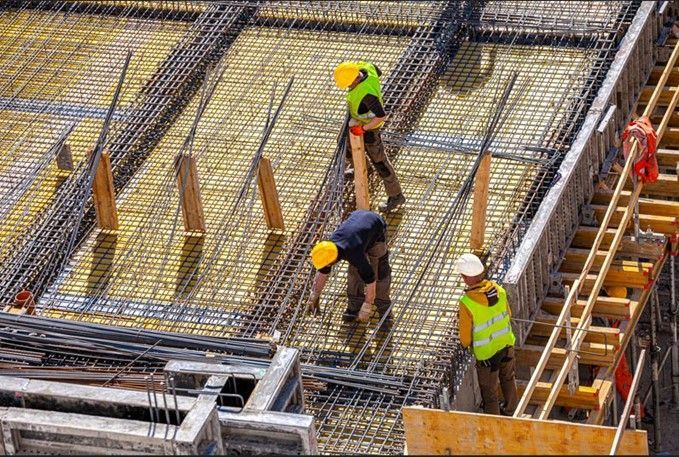 A group of construction workers are working on a construction site.