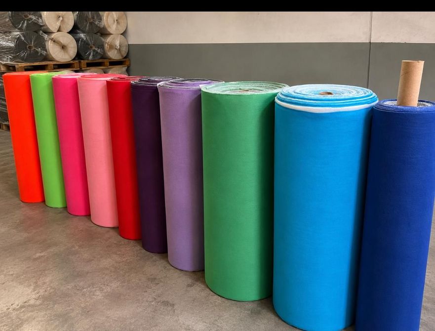 Esterillas de yoga enrolladas de colores brillantes, alineadas en el suelo.
