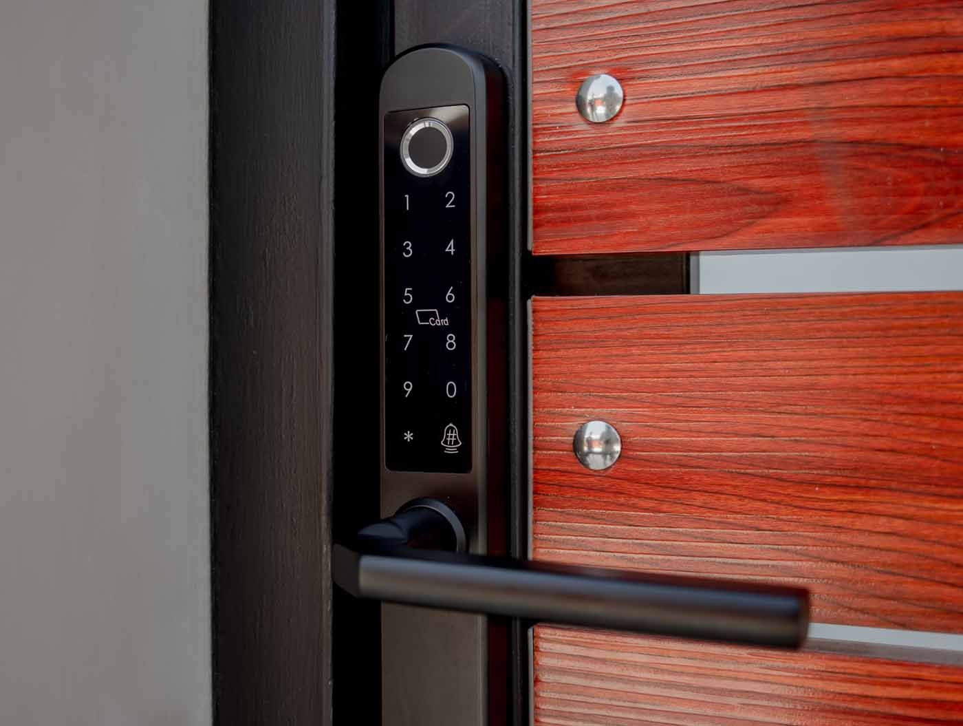 A close up of a smart door lock on a wooden door.